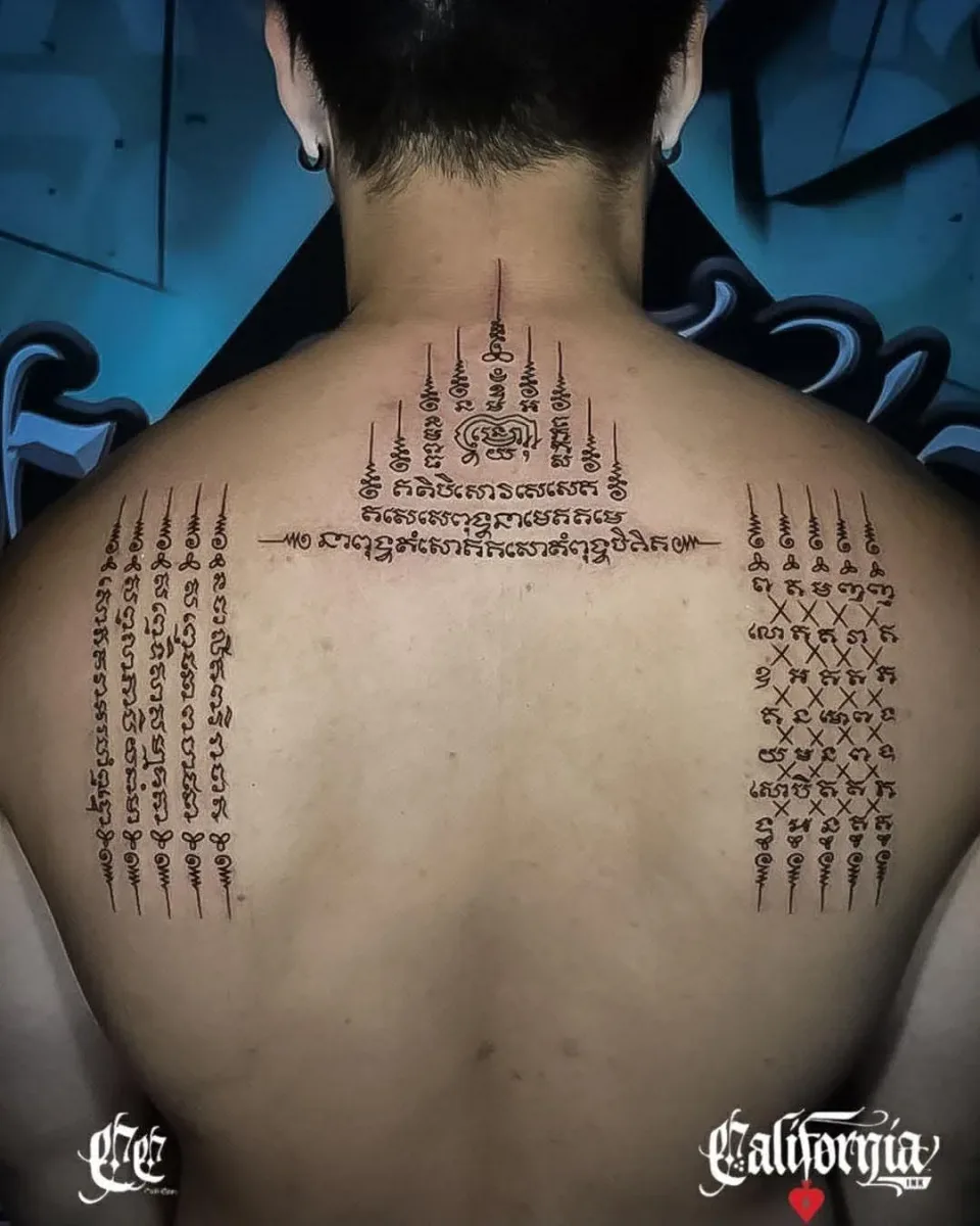 Sak Yant script tattoo across the upper back