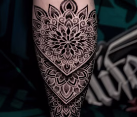 Mandala tattoo in a shield shape with radial floral detail