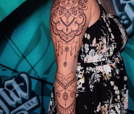 Mandala tattoo sleeve on woman's arm with delicate dotwork and jewelry-like patterns