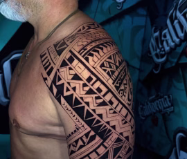 Maori-style tattoo covering the shoulder and upper arm