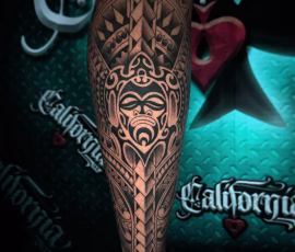 Maori-style tattoo with a carved face design
