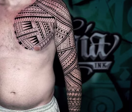Maori-style tattoo covering the shoulder, chest, and full arm