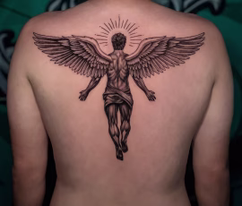 Micro realism tattoo of an angel in Thailand with outstretched wings and a sunburst halo, covering the upper back