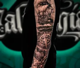 Black and grey pirate ship and compass sleeve tattoo