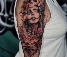 Contemporary tattoo sleeve of a skull and portrait with red floral accents