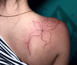 Contemporary tattoo of a fine line flower outline, on shoulder
