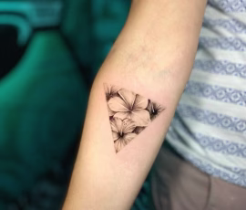 Micro realism tattoo of a small geometric triangle