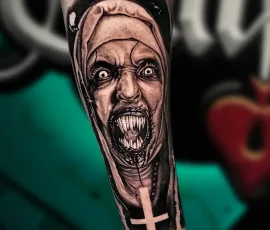 Black and grey horror nun portrait tattoo on a forearm