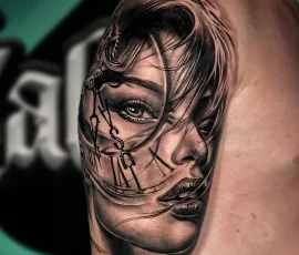 Surrealist black and grey tattoo blending a woman's face with an exposed mechanical or skeletal structure