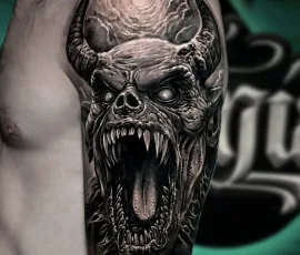 Black and grey realism tattoo of a screaming skull
