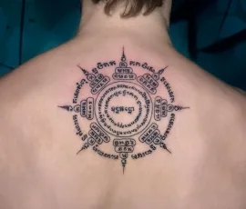 Sak Yant tattoo in a circular sacred script design, on upper back