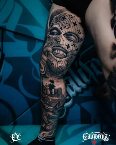 black and grey leg tattoo features a Chicano-inspired